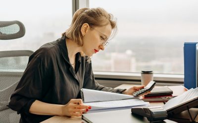 accountant focused on work, reading documents and holding a calculator