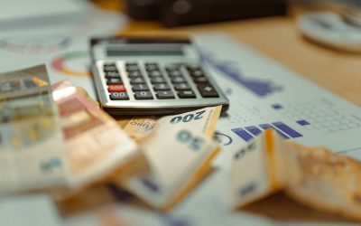 calculator, graphs, and bank notes on a desk