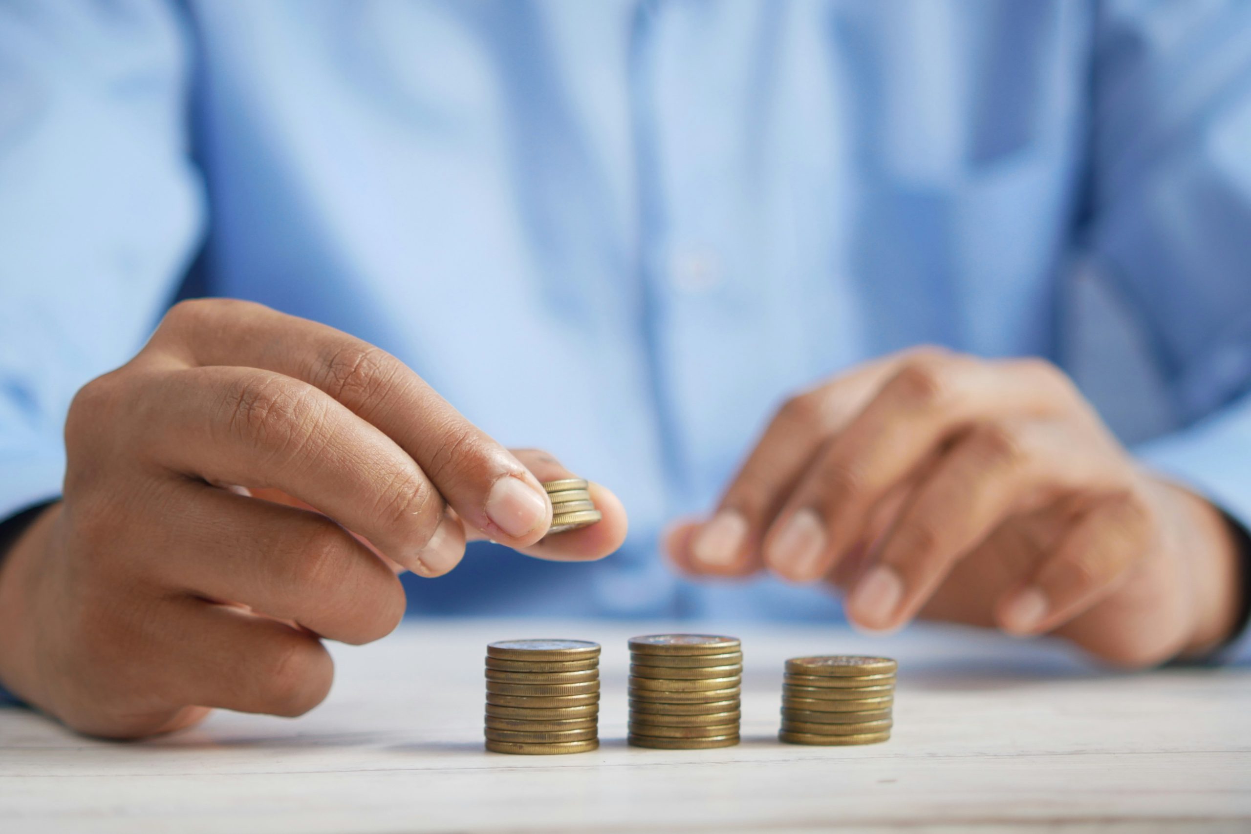 professionally dressed man stacking coins